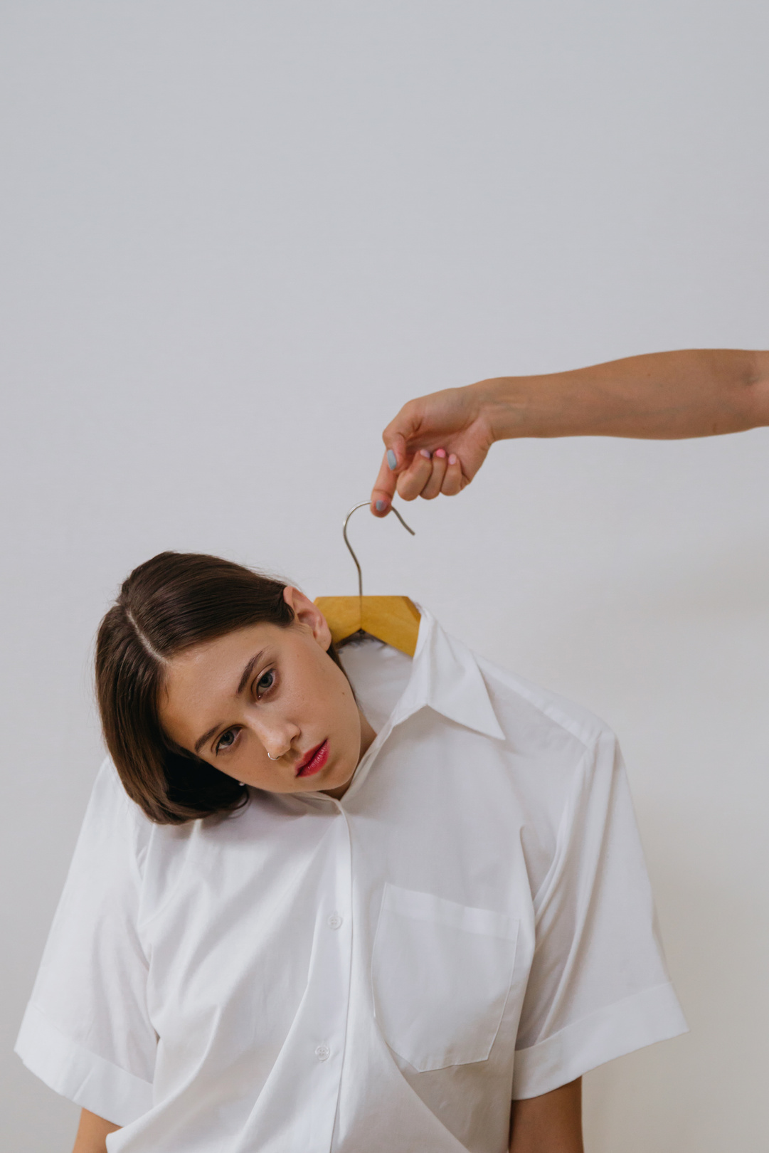 A Woman with a Clothes Hanger in her Shirt